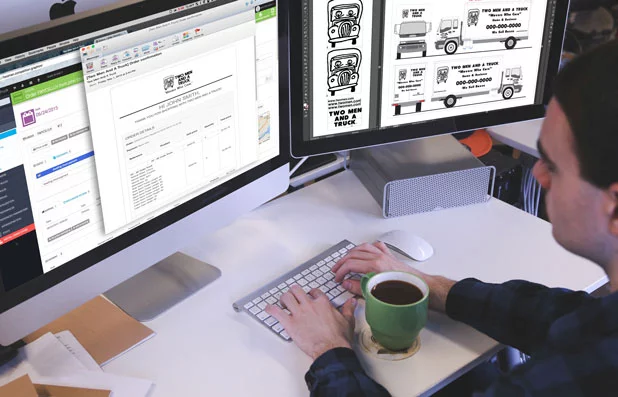 Man sitting at a computer viewing a customer's decal order and showing a sticker template on the screen